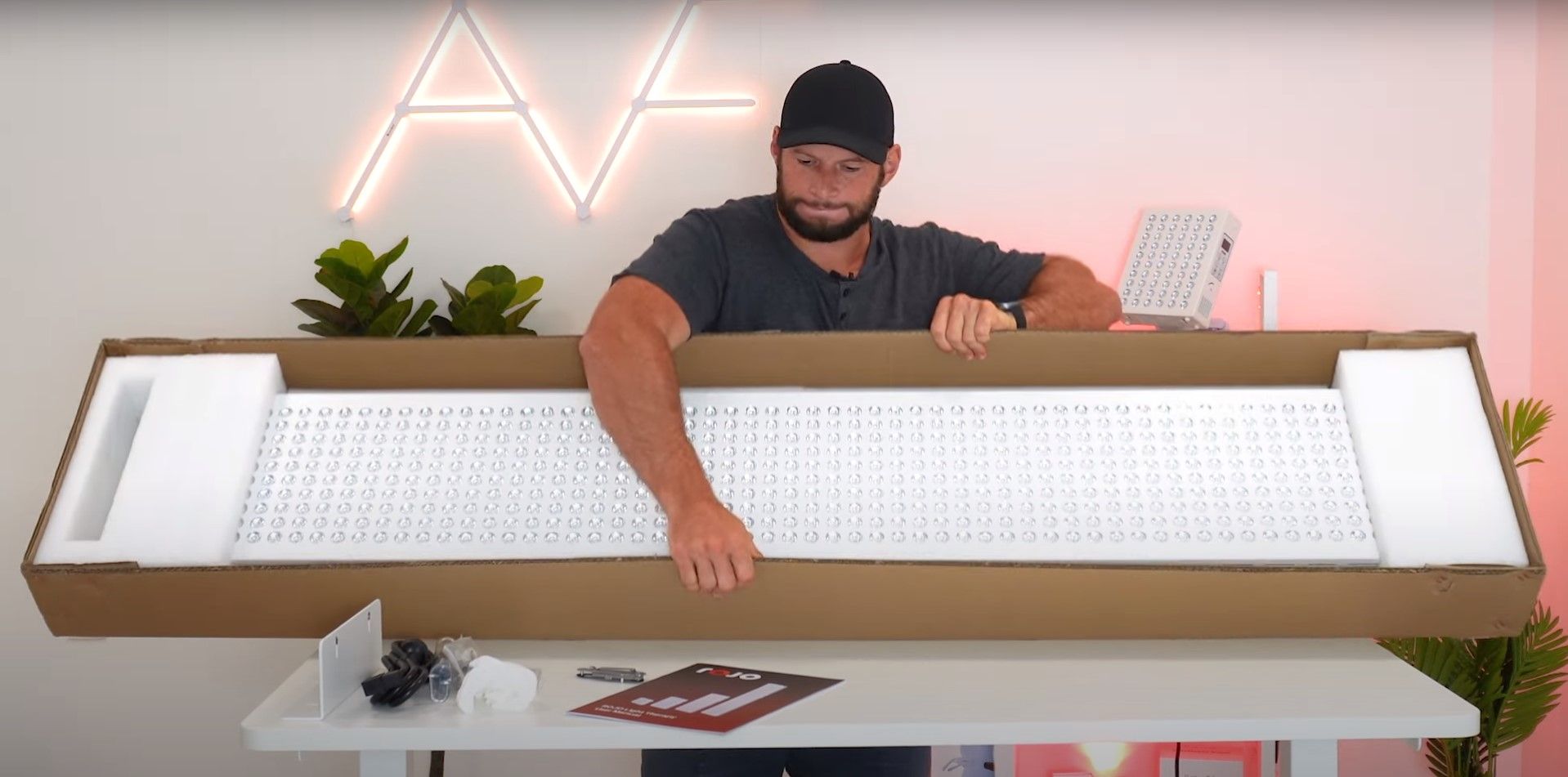 Alex Fergus unboxing a large red light therapy panel