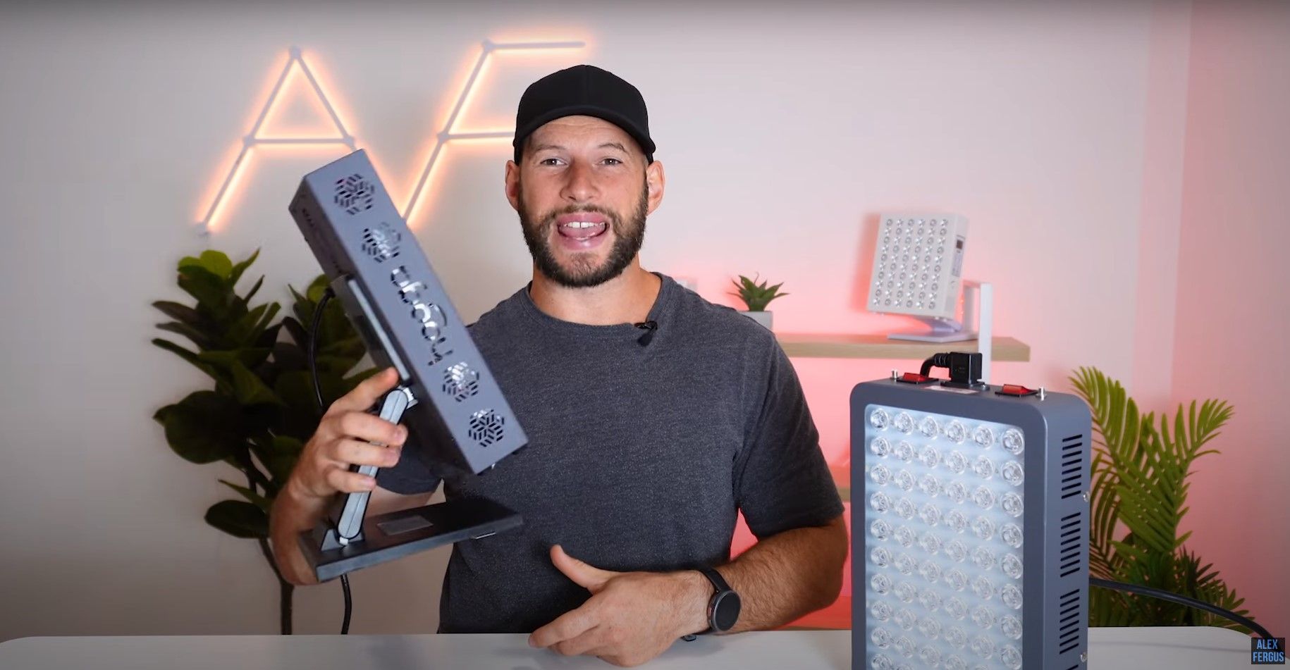 Alex holds the Hooga PRO 300 light therapy panel by its stand