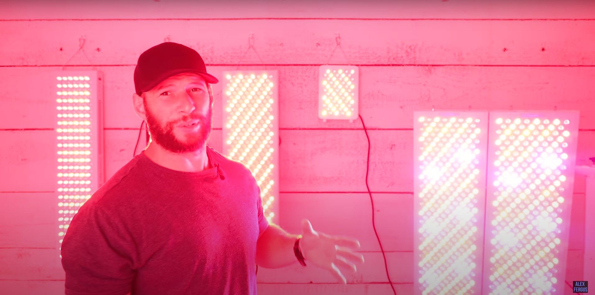 Alex Fergus standing in front of a variety of red light therapy panels