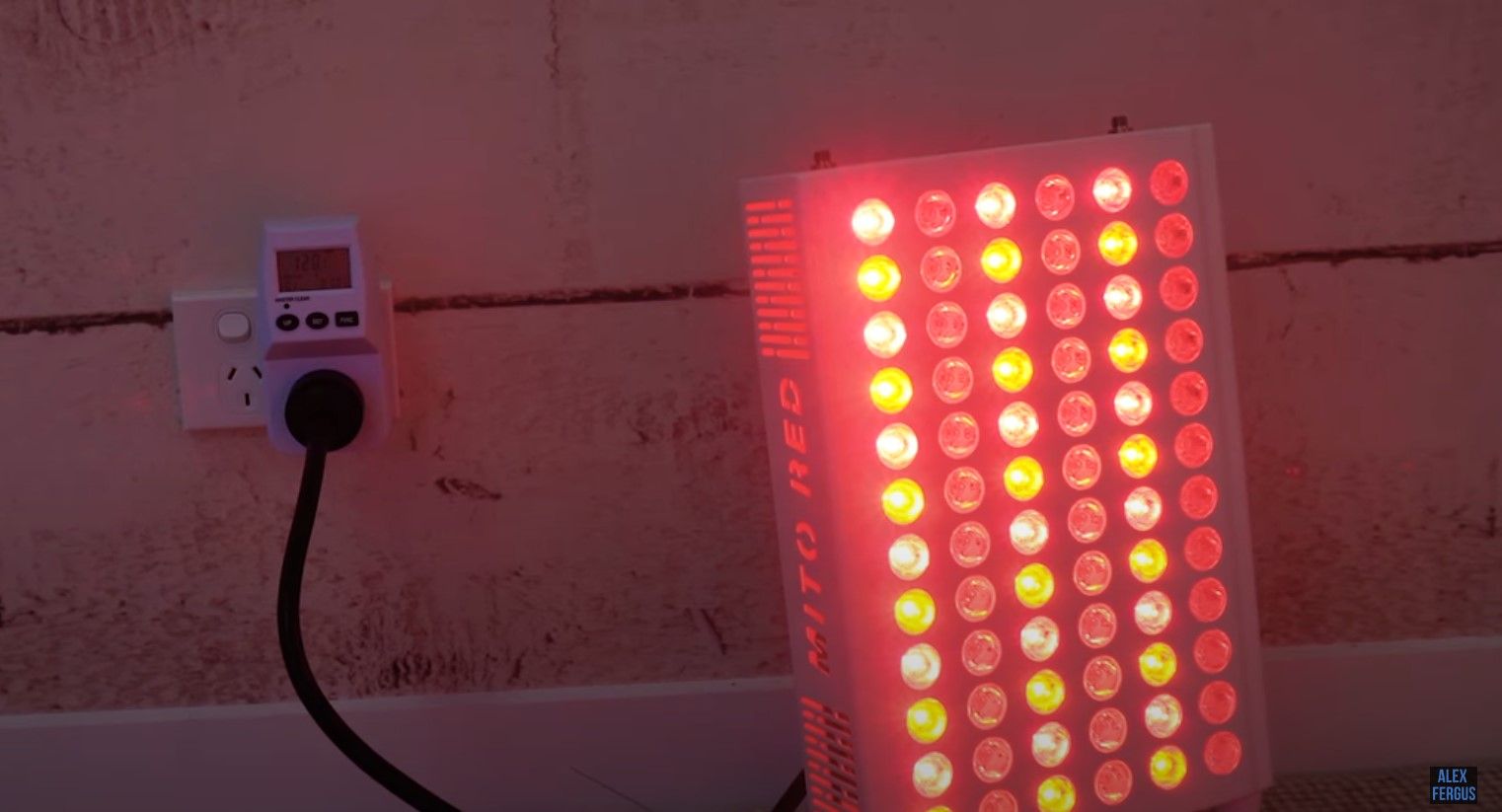 A Mito Red light therapy panel plugged into a device that measures power consumption.